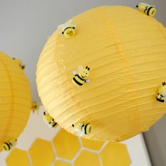 two honeybee paper lanterns hanging from the ceiling