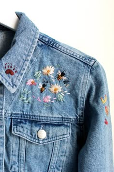 a denim jacket with embroidered flowers on it