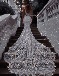 a woman is standing on some stairs wearing a dress made out of sparkling stars and sparkles