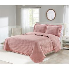 a bed with pink bedspread and pillows