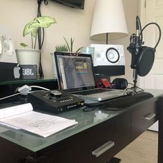 a laptop computer sitting on top of a desk next to a phone and headphones