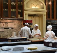 three chefs are in the kitchen preparing food