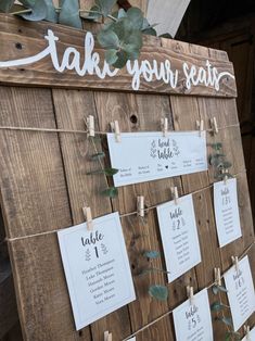 a wooden sign with seating cards attached to it