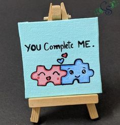 an easel with a painting on it that says you complete me and two hearts