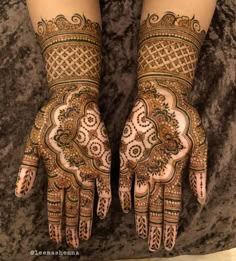 two hands with henna designs on them