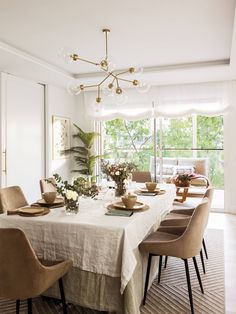 a dining room table with chairs and a white table cloth on top of the table