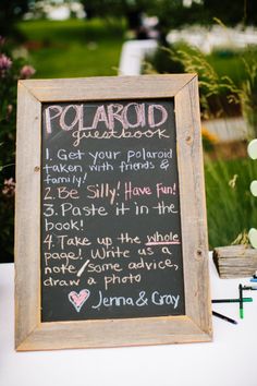 a chalkboard sign with writing on it sitting in front of some flowers and plants