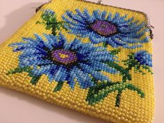 a yellow beaded purse with blue flowers on it