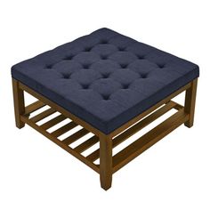 a square footstool with blue fabric on the top and wooden frame, in front of a white background