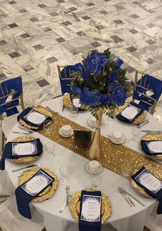 the table is set with blue and gold place settings