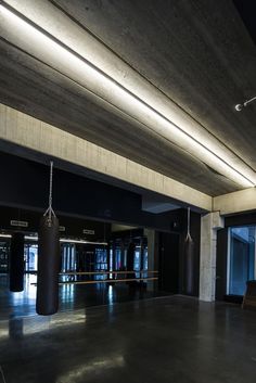 an empty gym with punching bags hanging from the ceiling