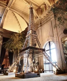 the eiffel tower is lit up at night with lights on it's sides