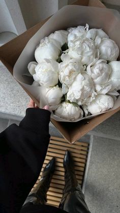 a person holding a bouquet of white flowers