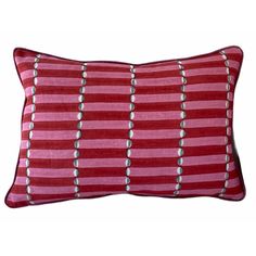 a red and pink striped pillow with silver circles on the front, sitting against a white background