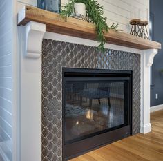 a fireplace with a plant on top of it and a shelf above the fire place