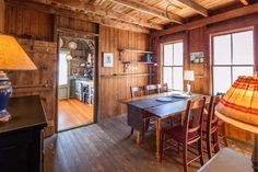 a room with wooden walls and flooring has a lamp on the table in front of it