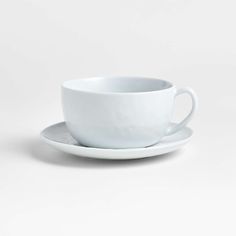 a white cup and saucer sitting on top of each other in front of a white background