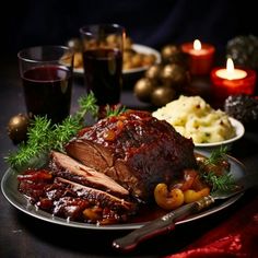 a plate with meat and vegetables on it next to some wine glasses, silverware and candles