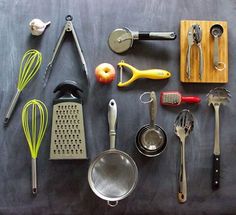 an assortment of kitchen utensils laid out on top of a black tablecloth