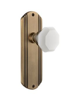 an antique brass door handle with a white knob