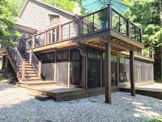 a house with a deck and an umbrella on the top floor in front of it