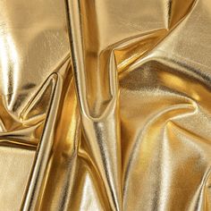 a shiny gold cloth is shown in close up view, it looks like the fabric has been