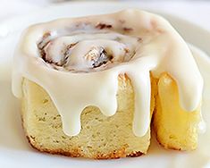 a white plate topped with a pastry covered in icing