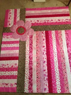 a pink and brown patchwork quilt on the floor