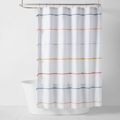 a white shower curtain with multicolored stripes on the bottom and bottom, hanging from a metal rod