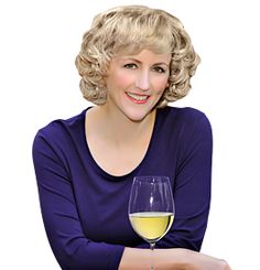 a woman sitting at a table with a glass of wine