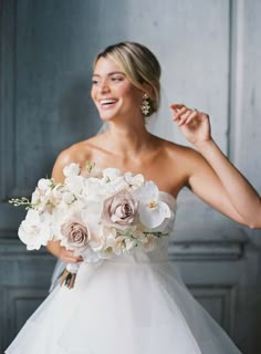 a woman in a white dress holding a bouquet of flowers