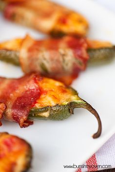 two pieces of food that are on a white plate with red and yellow toppings