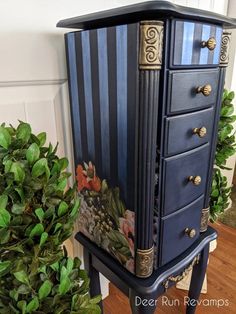 a blue and gold painted dresser next to a potted plant