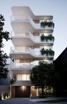 an apartment building with balconies and plants on the balconies is lit up at night