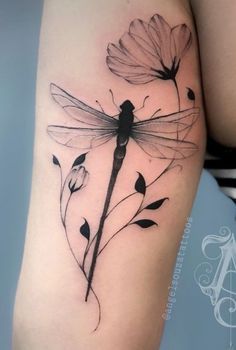 a woman's thigh with flowers and a dragonfly on it