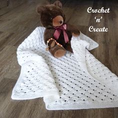 a brown teddy bear sitting on top of a white crocheted blanket with the words crochet in create written across it