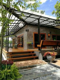 a modern house with wooden steps leading up to the front door and covered patio area