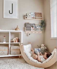 a young child laying in a hammock reading a book while sitting on the floor