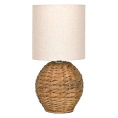 a wicker table lamp with a white shade