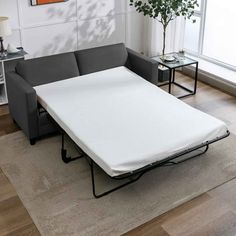 a couch with a pull out bed in the middle of it and a coffee table next to it