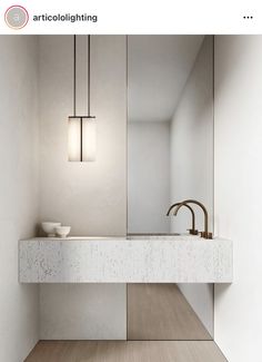 a white sink sitting under a bathroom mirror next to a wall mounted faucet