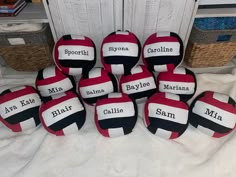 several balls with names on them sitting on a bed