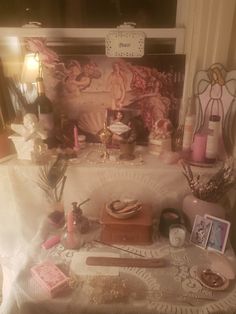 a table topped with lots of assorted items and candles on top of a white table cloth