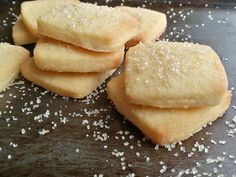 some sugar cookies are on a tray with white sprinkles around the edges