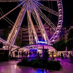 the ferris wheel is lit up at night