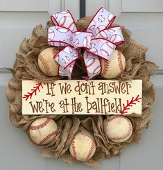 a wreath with baseballs and a sign that says if we don't answer, we're at the ballfield