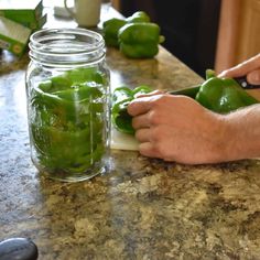 a person cutting up green peppers on a counter