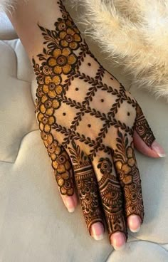 a woman's hand is decorated with hennap and gold flowers on it