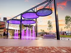 an outdoor fountain with purple lights on it