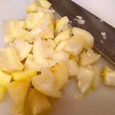 chopped pineapples on a cutting board next to a knife